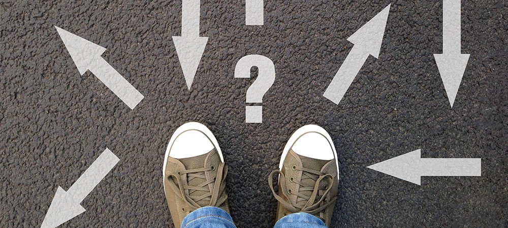 image of a persons feet with arrows going different directions, with a question mark above feet, which depicts someone deciding on how to choose the best wordpress page builders