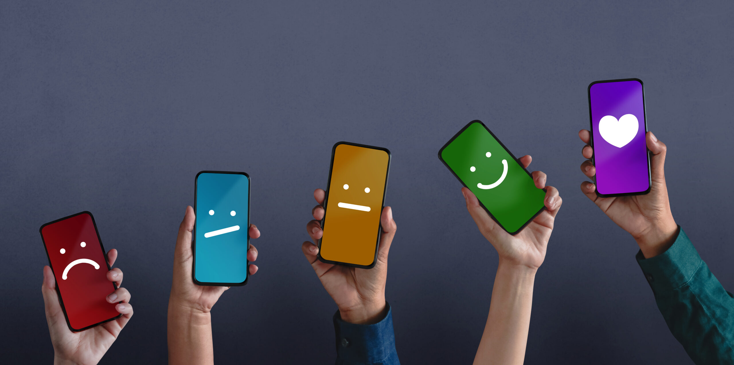 mobile devices held up by different people where the screens should different emoticons representing the experience of the user